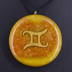 Round orange-yellow pendant necklace with gold Gemini symbol, close-up on black cord