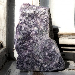 Large rough lepidolite stone standing upright, purple mottled texture