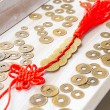 Close-up of five Chinese coins on red cord with red tassel, feng shui lucky coins