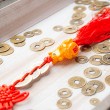 Close-up of feng shui charm with 3 Chinese coins, golden Pixiu bead and red tassel