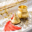 Brass Wu Lou gourd with red tassel next to opened gourd container and Chinese-style coins